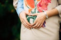 Pregnant Couple Making Heart Shape with Hands on Belly in The Park Outdoors. Royalty Free Stock Photo