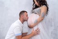 Pregnant couple. Man kissing his beautiful wife in belly. Waiting for a baby Royalty Free Stock Photo