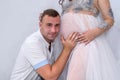 Pregnant couple. Man kissing his beautiful wife in belly. Waiting for a baby Royalty Free Stock Photo