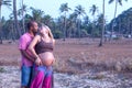 Pregnant couple walking on the beach