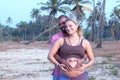 Pregnant couple walking on the beach