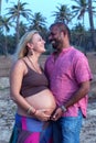 Pregnant couple walking on the beach