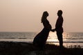 Pregnant couple walking on the beach Royalty Free Stock Photo