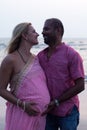 Pregnant couple walking on the beach