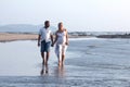 Pregnant couple walking on the beach