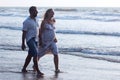 Pregnant couple walking on the beach