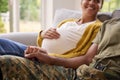 Pregnant Couple With Woman Sitting Next To Army Husband In Uniform Holding Hands Home On Leave Royalty Free Stock Photo