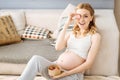 Pregnant delighted woman posing with macaroons