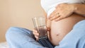 Pregnant drinking water. Young pregnancy mother drink water. Pregnant lady waiting of baby. Glass of water. Concept Royalty Free Stock Photo