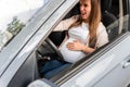 Pregnant driving car. Young smiling pregnancy woman driving car. Safety pregnant young mom driving concept.