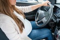 Pregnant driving car. Young smiling pregnancy woman driving car. Safety pregnant young mom driving concept.
