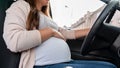 Pregnant driving car. Young smiling pregnancy woman driving car. Safety pregnant young mom driving concept.