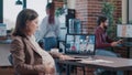 Pregnant employee using business video call on laptop to talk to workmates Royalty Free Stock Photo