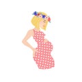 Pregnant european blonde woman wearing floral wreath and pink polka-dot dress.