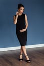 Pregnant european woman in black dress in dark flat, stylish and happy pregnant woman in apartments, beautiful pregnant