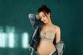 Pregnant european woman on blue background, beautiful young european woman waiting for a child, prenant woman with dark