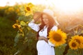 Pregnant european woman in a field of sunflowers, beautiful young european woman waiting for a child, prenant woman with Royalty Free Stock Photo