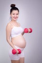 Pregnant exercises concept.A portrait of a Beautiful asian pregnant woman doing light exersice by using dumbell at home.