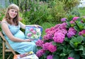 The pregnant female artist shows the watercolor drawing of the blossoming hydrangea
