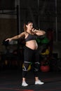 Pregnant female athlete doing hang kettlebell clean and press Royalty Free Stock Photo