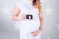 Pregnant female holding the image of the Fetal echocardiography under the lights