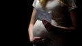 Pregnant female looking at baby x-ray, holding tummy, child awaiting, motherhood Royalty Free Stock Photo