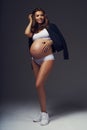 Pregnant female model in sports underwear standing and posing Royalty Free Stock Photo