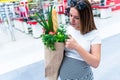 Pregnant food bag supermarket. Pregnancy woman with healthy lettuce salad leaves, fresh tomato in market food bag on Royalty Free Stock Photo