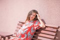 The pregnant girl basks in the sun. The concept of warm leisure - a beautiful pregnant girl with long hair, basking in a red dress Royalty Free Stock Photo