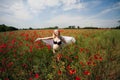 pregnant girl in black lingerie walks and rests in a meadow with poppy flowers Royalty Free Stock Photo