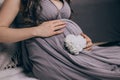 Pregnant girl in a dress holds her hands on her belly Royalty Free Stock Photo