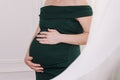 Pregnant girl in  dress holds her hands on her belly Royalty Free Stock Photo