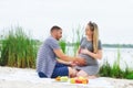 Pregnant girl and guy on a picnic by the river Royalty Free Stock Photo