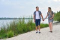 A pregnant girl and a guy walking along the river bank Royalty Free Stock Photo