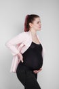 Pregnant girl holding on to her back. Pain, heaviness in the back. Royalty Free Stock Photo