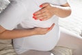 Pregnant girl holds on to the mammary gland. The concept of swelling and increase in the size of the female breast during Royalty Free Stock Photo