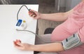 A pregnant girl measures blood pressure with a device. The concept of high and low blood pressure during pregnancy. Arterial Royalty Free Stock Photo