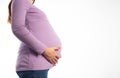 Pregnant girl in a purple sweater on a white background. The concept of weight gain during pregnancy. Overweight. Copy