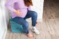 A pregnant girl puts on shoes with a big belly. Discomfort and inconvenience with bending over during pregnancy, problem