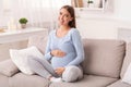 Pregnant Girl Touching Belly Smiling Sitting On Couch At Home Royalty Free Stock Photo