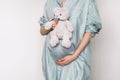 Pregnant girl touching belly and teddy bear toy resting, awaiting the child birth. Woman expecting baby. Natural Royalty Free Stock Photo