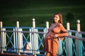 Pregnant girl walking along the promenade. Portrait of a girl with a stomach. A young girl in a summer dress walking along the Royalty Free Stock Photo