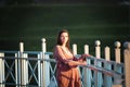 Pregnant girl walking along the promenade. Portrait of a girl with a stomach. A young girl in a summer dress walking along the