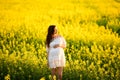 Pregnant girl on a yellow background. looks at his stomach, imagines his unborn child. Maternity concept Royalty Free Stock Photo