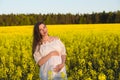 Pregnant happy woman touching her belly. Pregnant middle-aged mother portrait caressing her belly and smiling close-up. Healthy Royalty Free Stock Photo