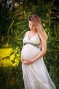 Pregnant happy Woman touching her belly. Pregnant middle aged mother portrait, caressing her belly and smiling close-up. Healthy P Royalty Free Stock Photo