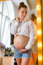 Pregnant happy woman touching her belly. Pregnant young mother portrait, caressing her belly and smiling. Healthy Pregnancy Royalty Free Stock Photo