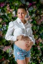 Pregnant happy woman touching her belly. Pregnant young mother portrait, caressing her belly and smiling. Healthy Pregnancy Royalty Free Stock Photo