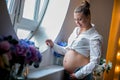 Pregnant happy woman touching her belly. Pregnant young mother portrait, caressing her belly and smiling. Healthy Pregnancy Royalty Free Stock Photo