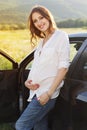 Pregnant happy young woman near car on the nature Royalty Free Stock Photo